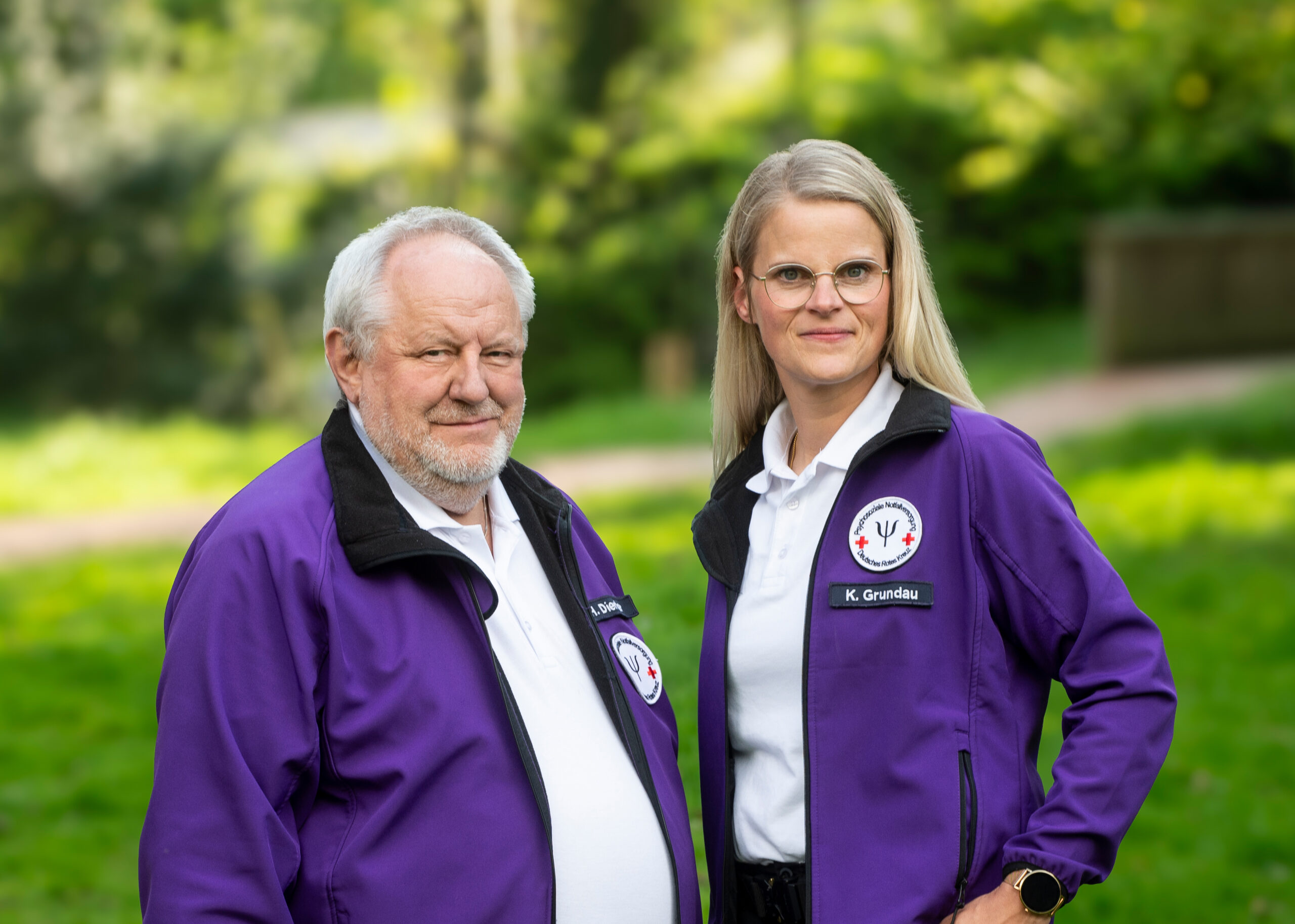 Zwei Mitglieder des PSNV-Teams in violetten Einsatzjacken